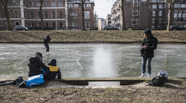 910710 Afbeelding van enkele schaatsers op een bevroren Stadsbuitengracht ter hoogte van de Catharijnesingel te Utrecht.